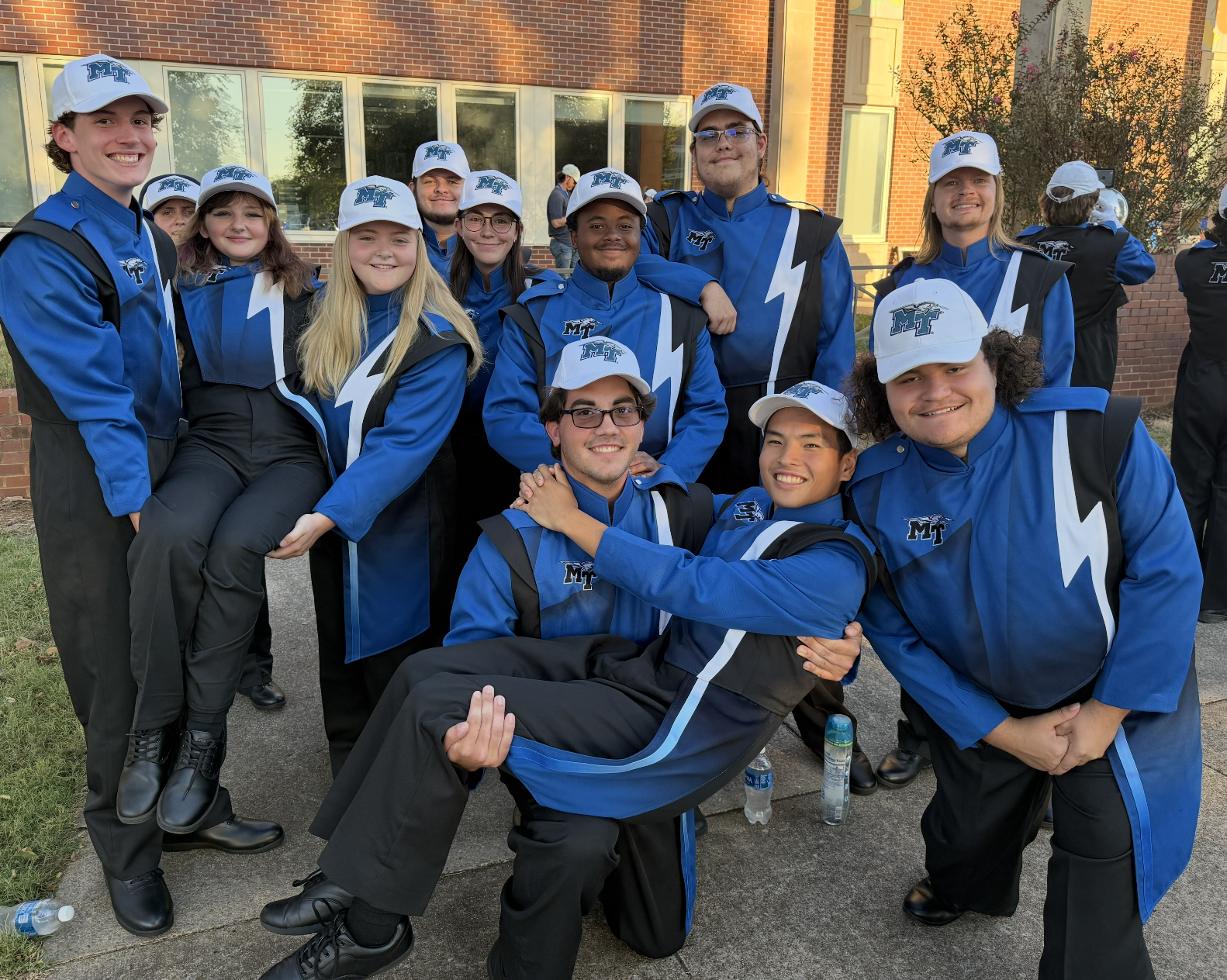 A group of MTSU Band of Blue Members smiling together assembled for this photo op.